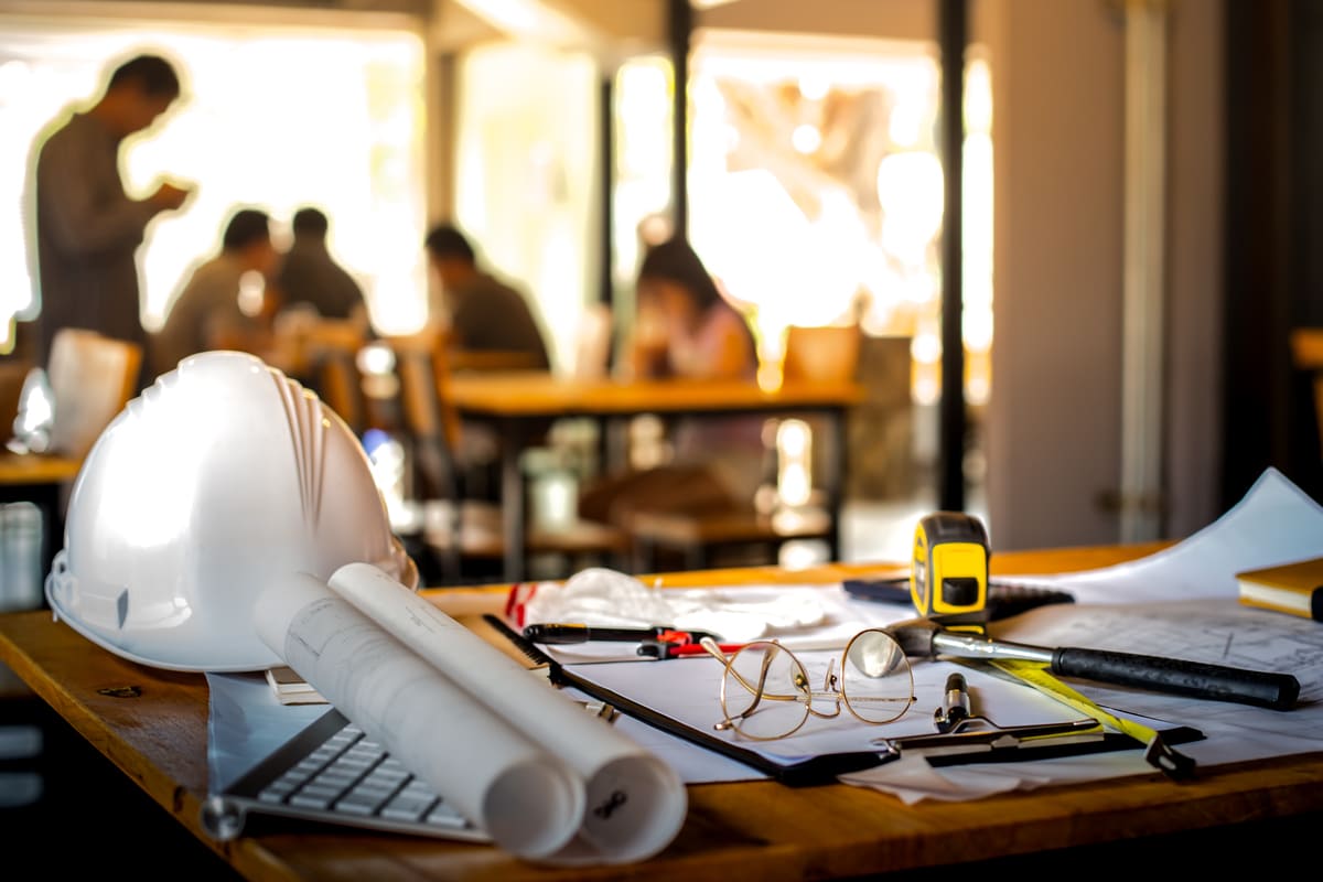 Table avec différents outils et un casque de construction.