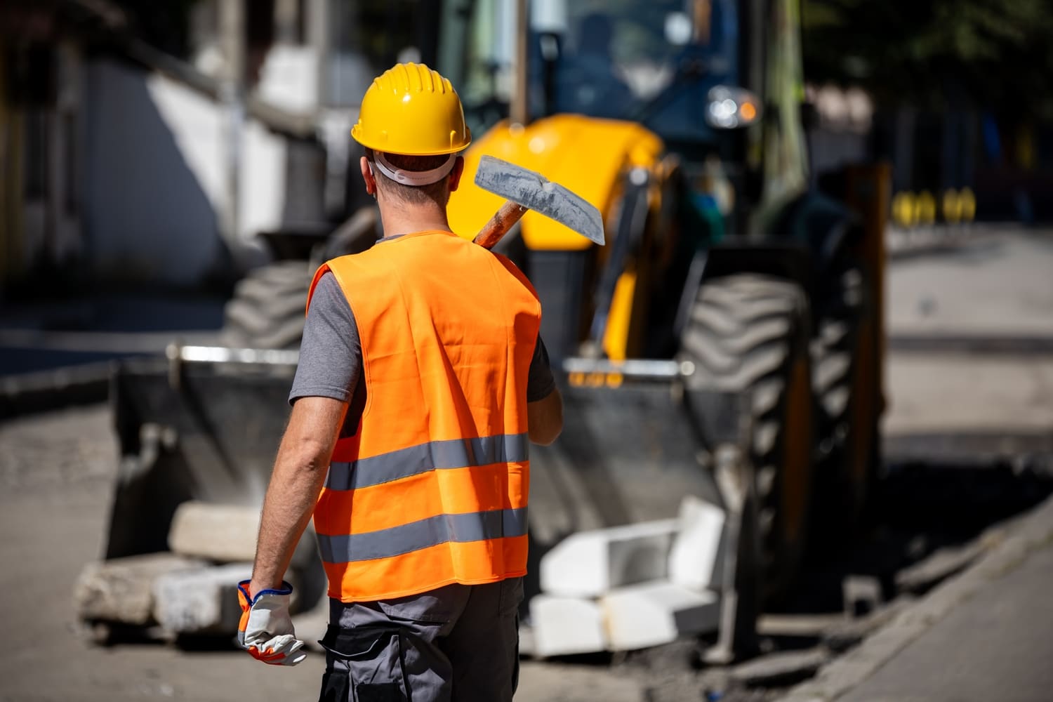 Ouvrier qui tient une pelle sur un chantier de construction.